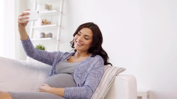 Gravid kvinna med selfy av smartphone hemma — Stockvideo