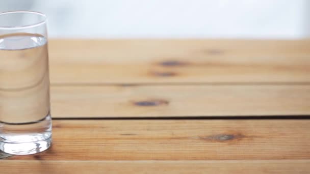 Woda wlanie do szkła na drewnianym stole — Wideo stockowe