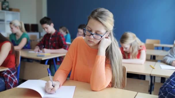 Студенты с блокнотами пишут тесты в школе — стоковое видео