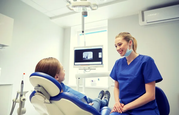 Dentista mujer feliz con chica paciente en la clínica —  Fotos de Stock