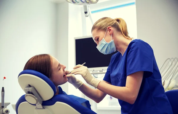 女性の歯科医が患者の少女の歯をチェック — ストック写真