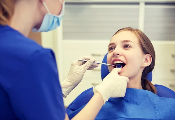 Dentista femenino chequeando dientes de niña paciente — Foto de Stock