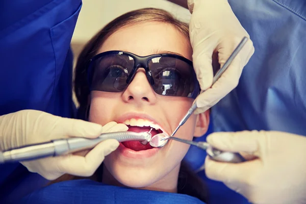 Dentistas mujeres que tratan los dientes de niña paciente —  Fotos de Stock