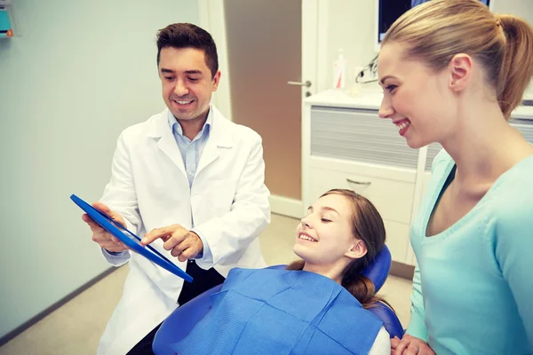 Dentiste montrant comprimé pc à la fille et sa mère — Photo