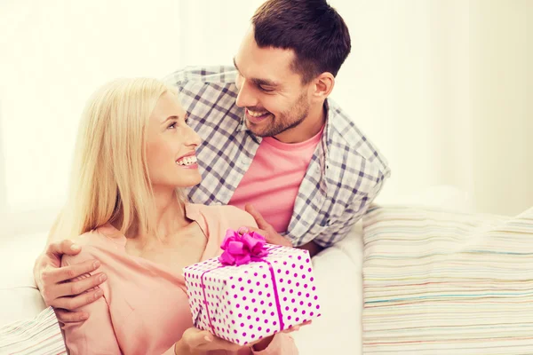 Glücklicher Mann schenkt Frau Geschenkbox zu Hause — Stockfoto