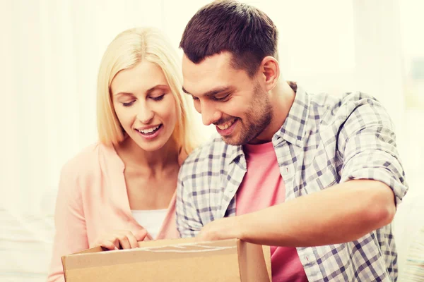 Casal feliz com caixa de pacote em casa — Fotografia de Stock