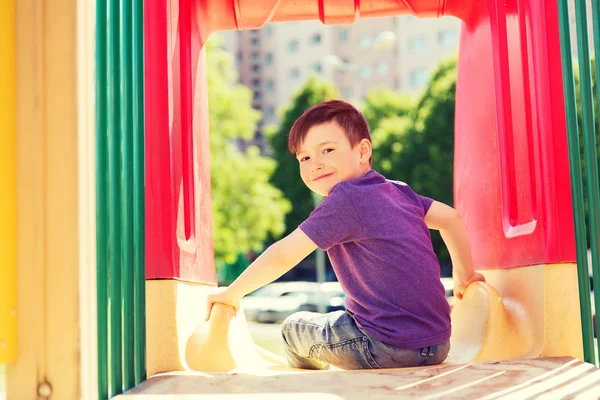 Счастливый мальчик на горке на детской площадке — стоковое фото