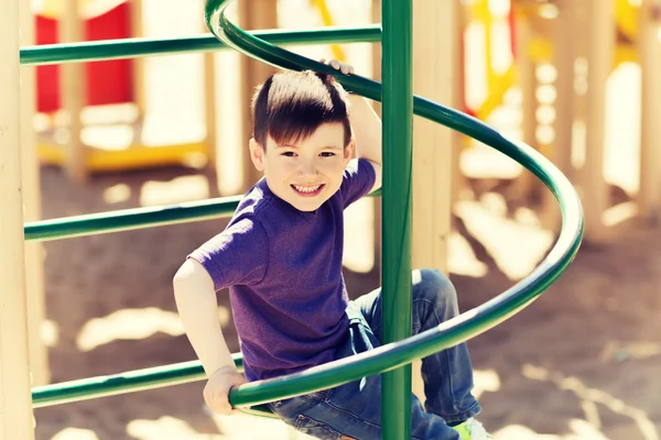 Fröhlicher kleiner Junge klettert auf Kinderspielplatz — Stockfoto