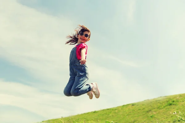 Happy little girl jumping high outdoors — Stock Photo, Image