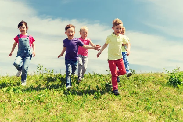 Skupina happy dětí běhá venku — Stock fotografie