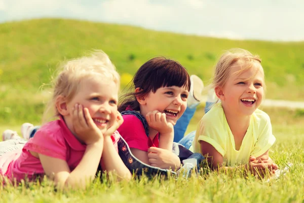 Group of kids lying on blanket or cover outdoors — Stock Photo, Image