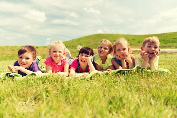 Gruppo di bambini sdraiati sulla coperta o al coperto all'aperto — Foto Stock