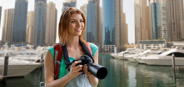 Mulher com mochila e câmera sobre a cidade de Dubai — Fotografia de Stock