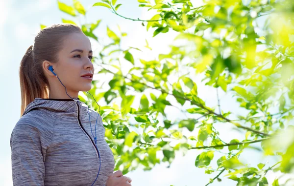 Mujer feliz con auriculares corriendo en la ciudad — Foto de Stock