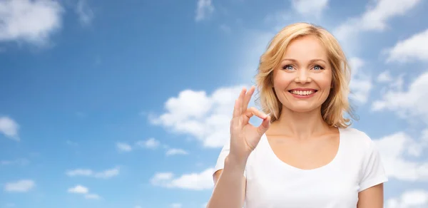 Happy woman in white t-shirt showing ok hand sign — Stock Photo, Image