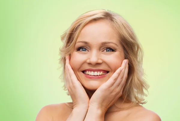 Femme souriante aux épaules nues touchant le visage — Photo