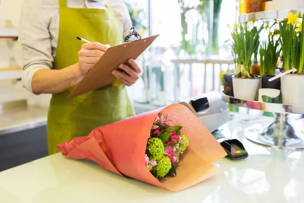 Primer plano del hombre con portapapeles en la tienda de flores —  Fotos de Stock