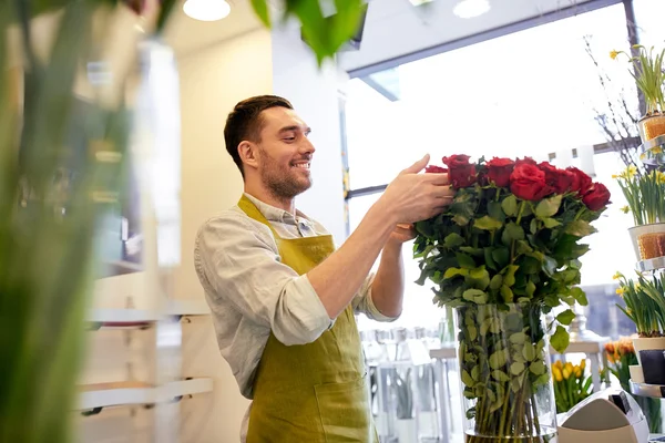 Florista sonriente hombre con rosas en la floristería — Foto de Stock