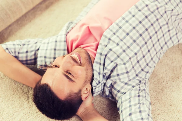 Hombre feliz acostado alfombra o alfombra en casa Imagen de archivo