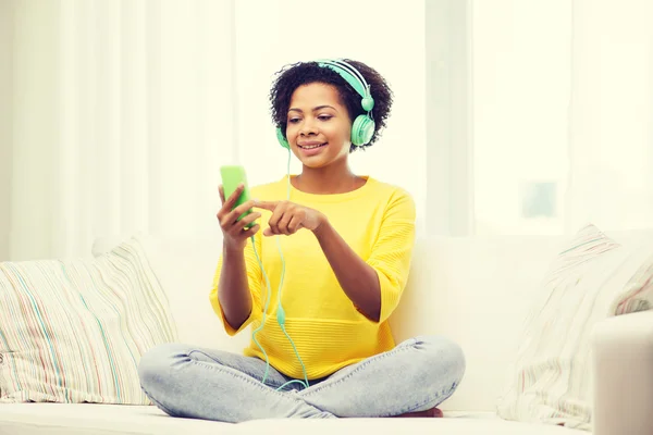 Mulher africana feliz com smartphone e fones de ouvido — Fotografia de Stock