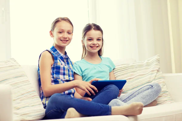 Filles heureuses avec tablette PC assis sur le canapé à la maison — Photo