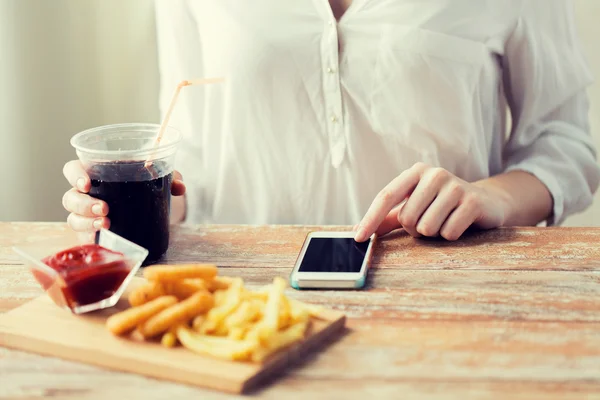 Primer plano de la mujer con el teléfono inteligente y la comida rápida — Foto de Stock