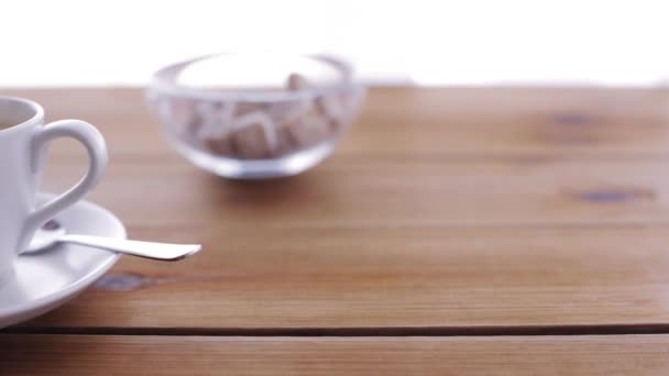 Crema que vierte a la taza de café en la mesa de madera — Vídeo de stock