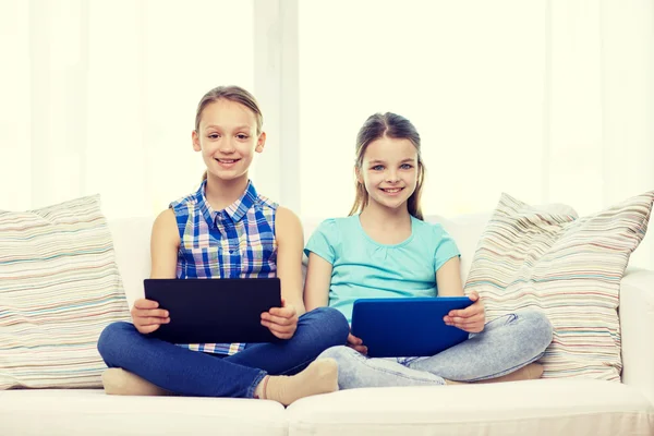 Glückliche Mädchen mit Tablet-PC zu Hause auf dem Sofa sitzend — Stockfoto
