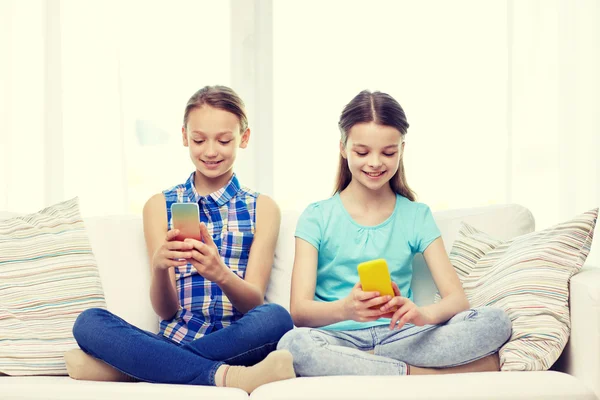 Šťastné holky s smartphone sedí na pohovce — Stock fotografie