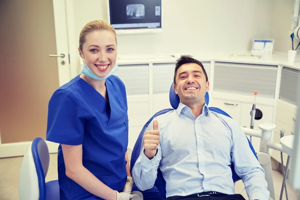 Dentista mujer feliz con el hombre paciente en la clínica —  Fotos de Stock