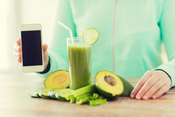 Närbild på kvinna med smartphone och grönsaker — Stockfoto