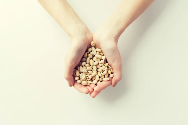 Primer plano de las manos de mujer sosteniendo cacahuetes pelados — Foto de Stock