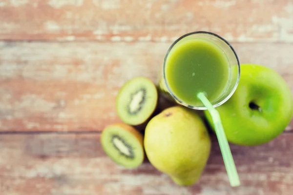 Primer plano de jugo verde fresco y frutas en la mesa — Foto de Stock