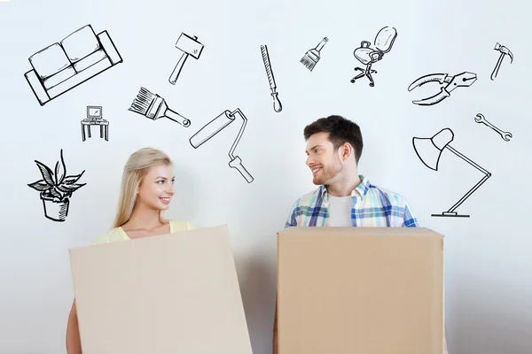 Coppia sorridente con grandi scatole trasferirsi in una nuova casa — Foto Stock