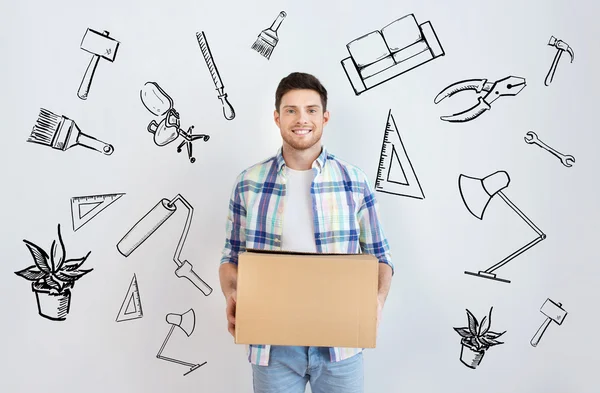 Sonriente joven con caja de cartón en casa — Foto de Stock