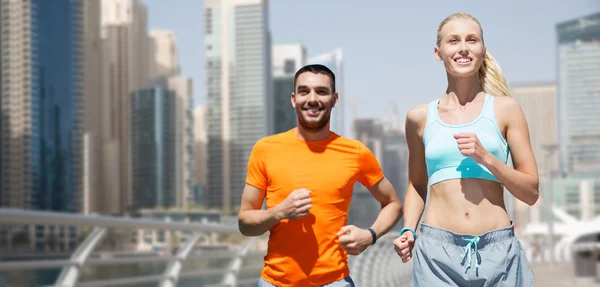 Couple running over dubai city street background — Stock Photo, Image