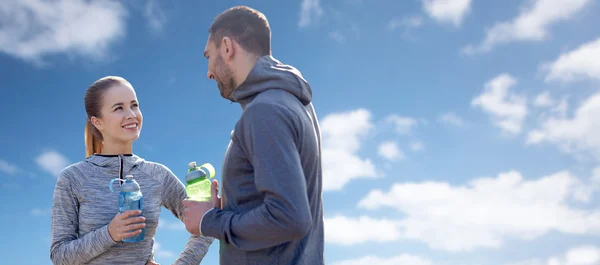 Ler par med flaskor vatten under blå himmel — Stockfoto