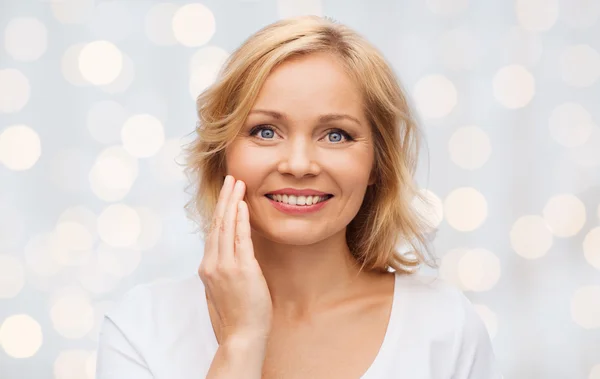 Femme souriante en t-shirt blanc touchant son visage — Photo