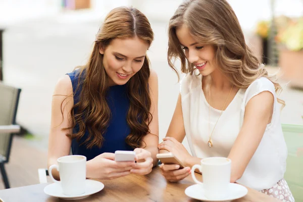 Women with smartphones and coffee at outdoor cafe — Stock Photo, Image