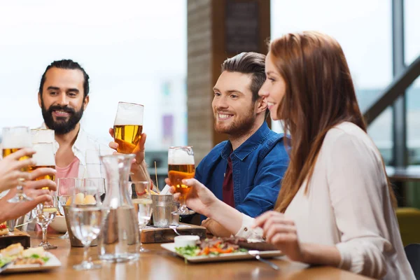 Vänner som äter och dricker öl på restaurang — Stockfoto