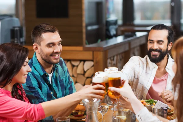 Přátelé stolování a pití piva v restauraci — Stock fotografie