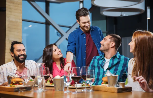 Amigos jantar e beber vinho no restaurante — Fotografia de Stock