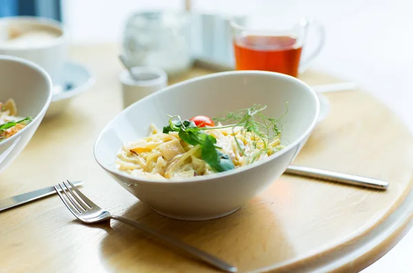 Close up of pasta in bowl on table at restaurant — Stock Photo, Image