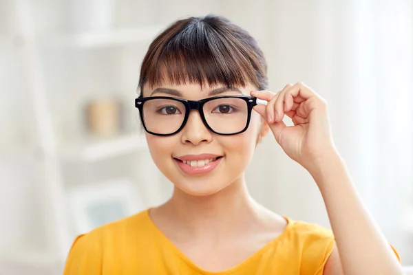 Feliz asiático joven mujer en gafas en casa —  Fotos de Stock