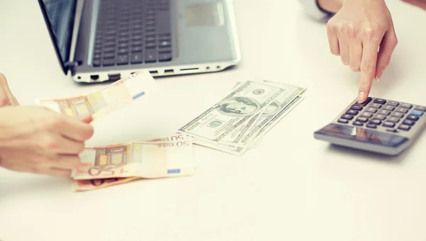 Close up of hands counting money with calculator — Stock Photo, Image