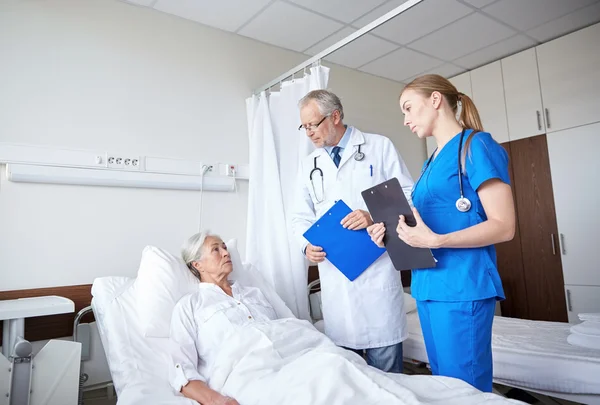 Arts en verpleegkundige senior vrouw in ziekenhuis bezoeken — Stockfoto