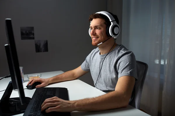 Uomo in cuffia giocare al videogioco per computer a casa — Foto Stock