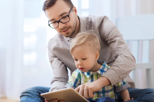 Pai e filho com tablet pc jogando em casa — Fotografia de Stock