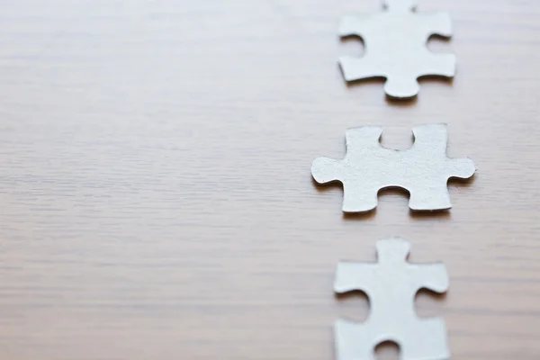 Close up van puzzelstukjes op houten oppervlak — Stockfoto