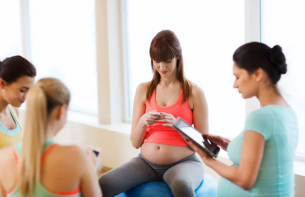 Glada gravida kvinnor med prylar i gym — Stockfoto